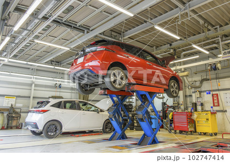 自動車整備工場――リフトに乗せられた車両 102747414