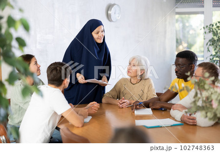 Young Asian female student discussing study topics with coursemates 102748363