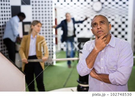 Portrait of bewildered man spending time with colleagues in quest room Portrait of bewildered man spending time with colleagues in quest room 102748530