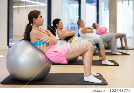 Young woman training pilates at group class Young woman training pilates at group class 102748770