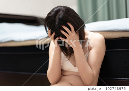 下着姿で座り込む女性 102748976
