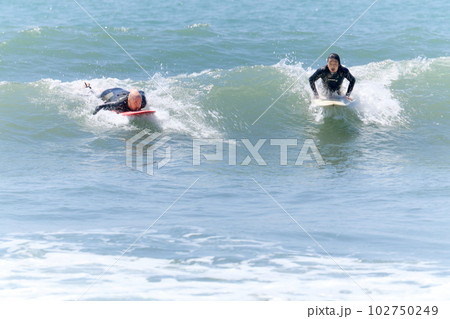 サーフィンを楽しむ2人の男性 102750249