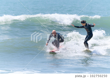 サーフィンを楽しむ2人の男性 102750250