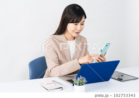 ノートパソコンとスマートフォンを使う若い女性 ビジネスイメージ ノートパソコンとスマートフォンを使う若い女性 ビジネスイメージ 102753343
