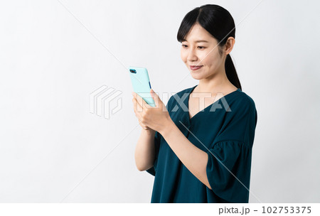 笑顔でスマートフォンを持つ若い女性 102753375