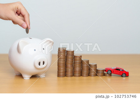 Money Saving, Car Insurance, Financial, vehicle Repair and Maintenance concepts. hand putting coin into piggy bank with Auto model, Money stack Counting arrangement for deposit and Automobile Tax Money Saving, Car Insurance, Financial, vehicle Repair and Maintenance concepts. hand putting coin into piggy bank with Auto model, Money stack Counting arrangement for deposit and Automobile Tax 102753746