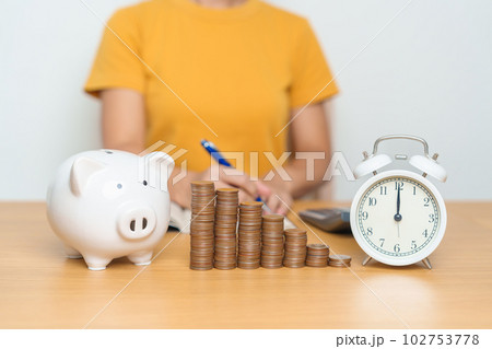 Money Saving for Future Plan, Retirement fund, Pension, Investment, Wealth Business and Financial concepts. woman with coins stack, piggy bank and clock for money Counting and deposit 102753778