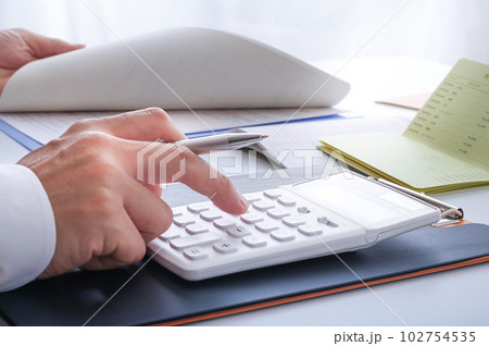 電卓でお金の計算をする人の手元 電卓でお金の計算をする人の手元 102754535
