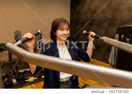 フィットネスジムで普段着でパーソナルトレーニングをする若い女性　コンビニジムイメージ 102756169