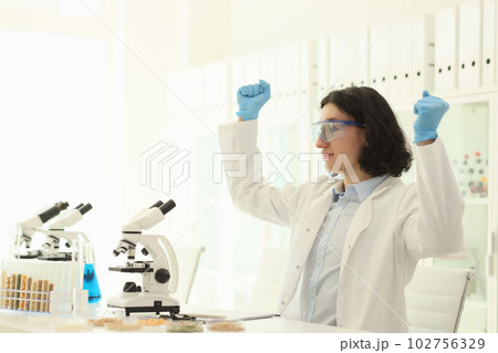 Joyful male scientist in protective goggles raises hands Joyful male scientist in protective goggles raises hands 102756329