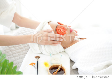 Masseuse masking face with tomato and spa face woman treatment and massage aroma therapy 102758502