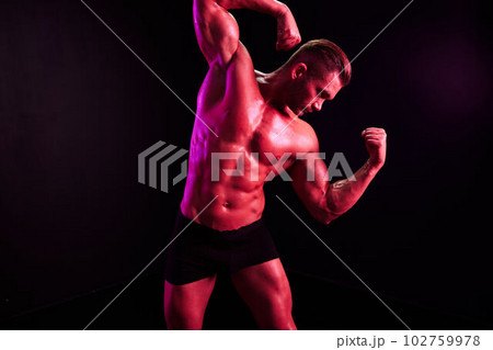 Man professional athletes with naked torso in athletic uniforms, isolated on a multicolored background in neon light. Advertising, sports, active lifestyle, competition, challenge concept 102759978