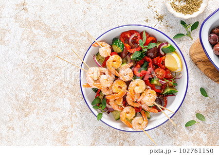 Shrimp kebab roasted on skewers and fresh vegetable salad, top view 102761150
