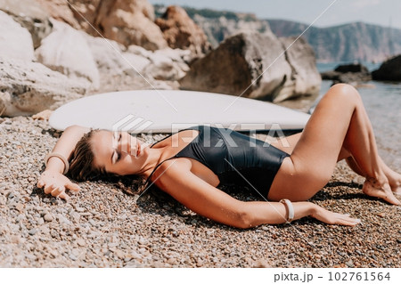 Woman sea sup. Close up portrait of happy young caucasian woman with long hair looking at camera and smiling. Cute woman portrait in bikini posing on sup board in the sea Woman sea sup. Close up portrait of happy young caucasian woman with long hair looking at camera and smiling. Cute woman portrait in bikini posing on sup board in the sea 102761564