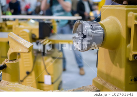 Close up view: wood turning lathe machine with shavings at workshop Close up view: wood turning lathe machine with shavings at workshop 102761943