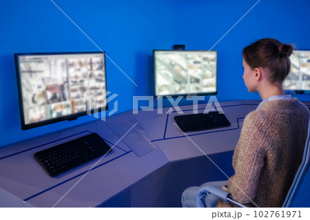 Woman security guard looking at modern cctv camera monitors 102761971