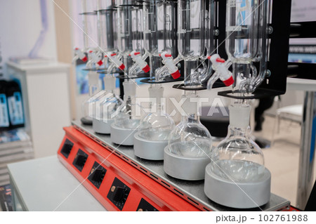 Laboratory equipment - empty glass vials on heating mantle in row 102761988