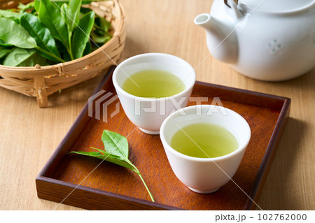 急須で淹れたお茶と生の茶葉 102762000