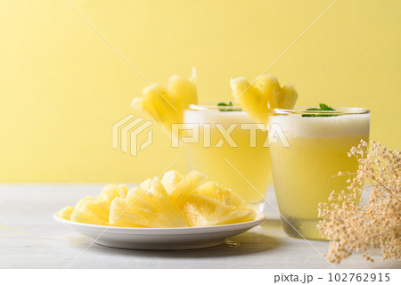 Pineapple smoothie in glass with sliced pineapple fruit, Tropical summer drink 102762915