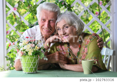 Beautiful elderly couple sitting at the table at the country house 102763316