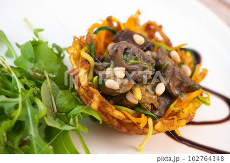 Recipe for poultry giblets in a nest of fried potatoes with rocket and tomato salad 102764348