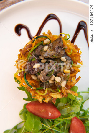 Recipe for poultry giblets in a nest of fried potatoes with rocket and tomato salad 102764474