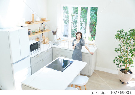 キッチンでコーヒーを飲む若い女性 キッチンでコーヒーを飲む若い女性 102769003