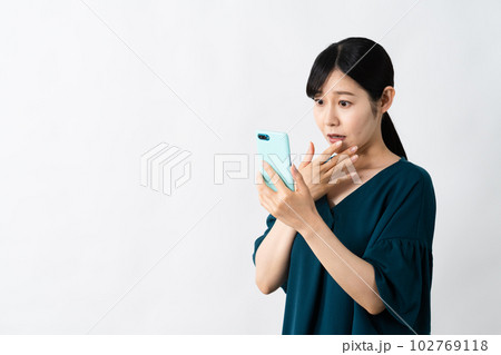 スマートフォンを持ちながらネガティブな表情をする若い女性 スマートフォンを持ちながらネガティブな表情をする若い女性 102769118