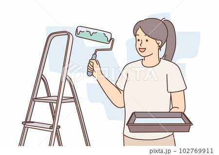 Woman molar with roller for painting walls stands near ladder making repairs in apartment 102769911