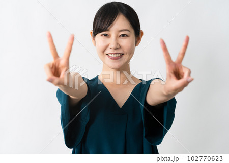 ポラロイド写真 ピースサイン 女性 ピースサインをする若い女性 ライフスタイルイメージの写真素材