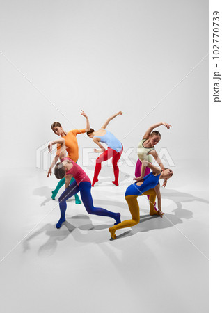 Creative, talented young girls, ballerinas in colorful bright tights dancing against grey studio background. Game of shadows Creative, talented young girls, ballerinas in colorful bright tights dancing against grey studio background. Game of shadows 102770739
