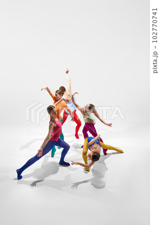 Top view. Creative, expressive young girls, ballerinas in colorful bright tights dancing against grey studio background Top view. Creative, expressive young girls, ballerinas in colorful bright tights dancing against grey studio background 102770741