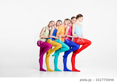 Friendship. Young girls, ballerinas in colorful bodysuits and tights standing closely to each other against grey studio background Friendship. Young girls, ballerinas in colorful bodysuits and tights standing closely to each other against grey studio background 102770846