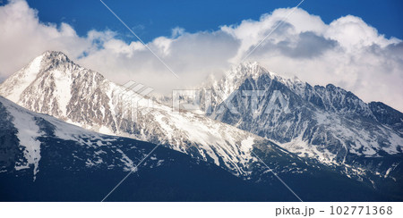 slovakia countryside in spring. snowcapped peaks beneath huge white clouds. nature background in gorgeous light 102771368
