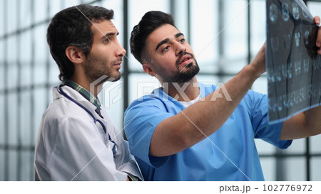 Two male doctors looking at brain x-ray 102776972