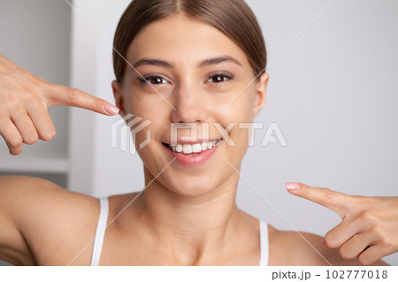 Woman with strong white teeth looking at camera and smiling Woman with strong white teeth looking at camera and smiling 102777018