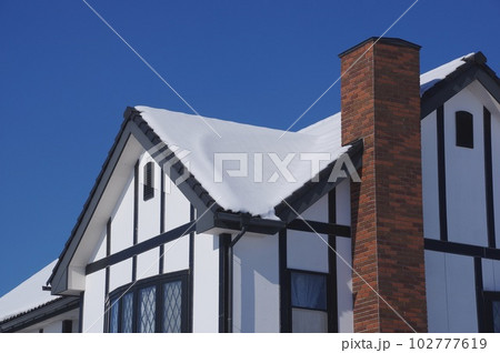 積雪の屋根と煙突の風景　 102777619