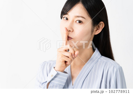 口に指を当てる若い女性　ビジネスイメージ 102778911
