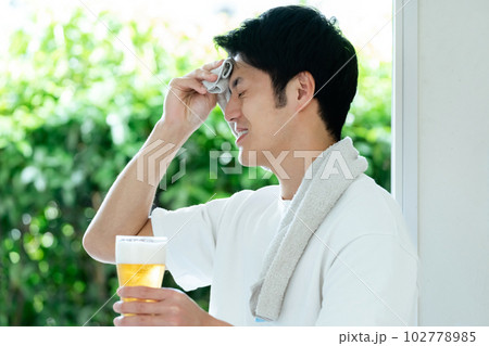 休日にビールを飲む男性 102778985