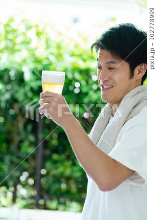 休日にビールを飲む男性 102778999