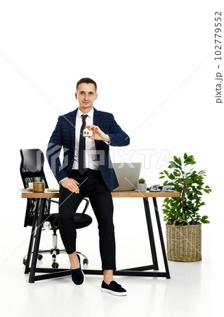 Successful caucasian businessman holding toy house in the office. real estate insurance Successful caucasian businessman holding toy house in the office. real estate insurance 102779552