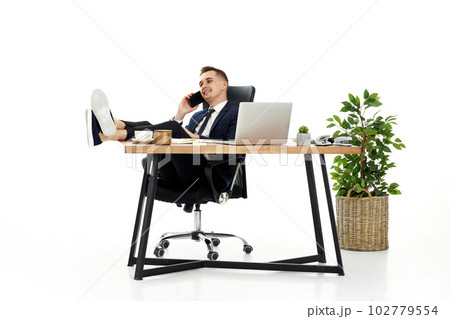 businessman working with laptop and having phone conversation with client 102779554