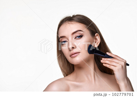 smiling lovely lady posing with make-up brush for powder 102779701