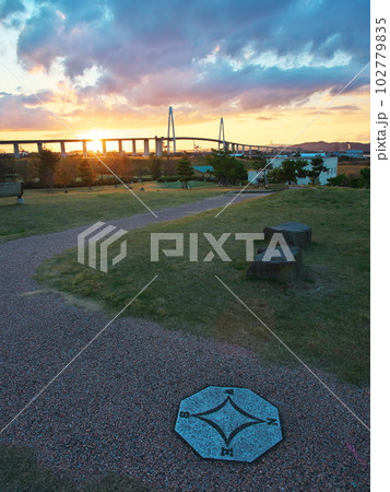 富山県射水市　富山新港元気の森公園から夕焼けの新湊大橋を臨む 102779835