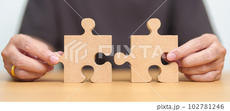 Hand connecting couple puzzle piece. Business Solving, mission, challenge, success, goals, target and strategy concepts Hand connecting couple puzzle piece. Business Solving, mission, challenge, success, goals, target and strategy concepts 102781246