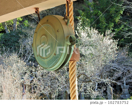 神社仏閣の正面に吊るされた丸い銅製の鰐口 102783752