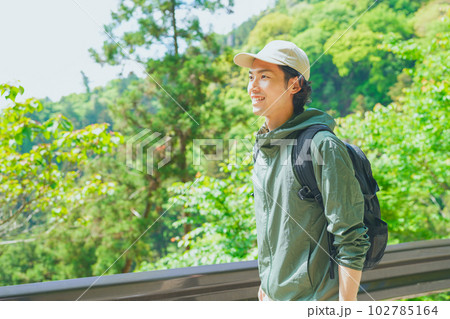 美しい新緑の山でハイキングをする若い男性 102785164