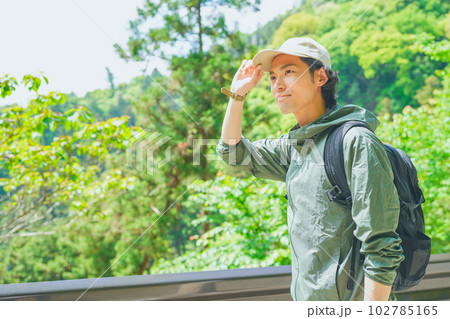 美しい新緑の山でハイキングをする若い男性 102785165