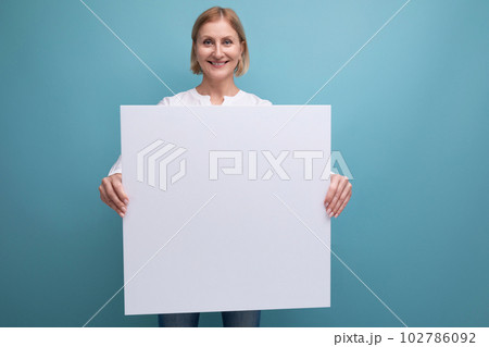 middle aged woman holding blank white paper for news with mocup middle aged woman holding blank white paper for news with mocup 102786092