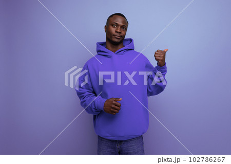 energetic positive young african man consultant in stylish hoodie shows with hand actual offer on 102786267